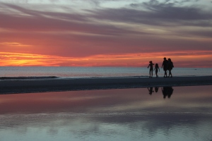 A family walking along the beach in Marco Island, Florida